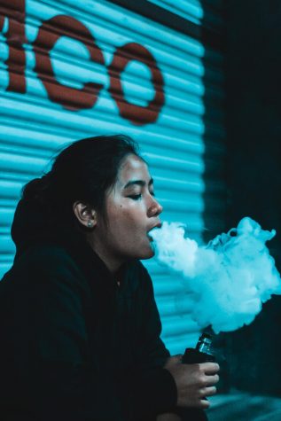 Girl vaping, releasing vapor
