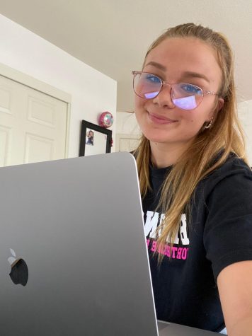 Girl sitting working on laptop.
