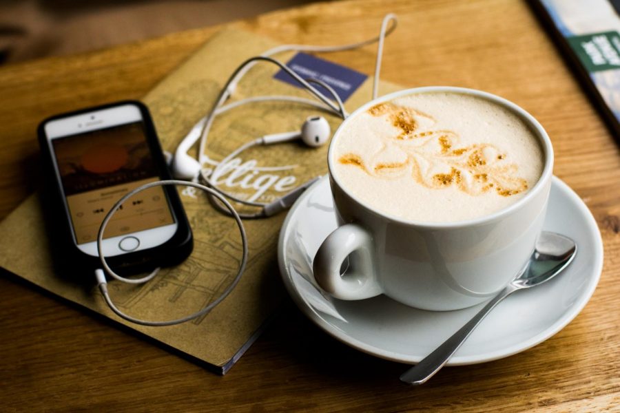 Coffee on table with iPhone and ear buds
