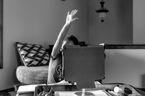 Student working on laptop alone, face blocked