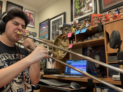 Male student playing trombone at home