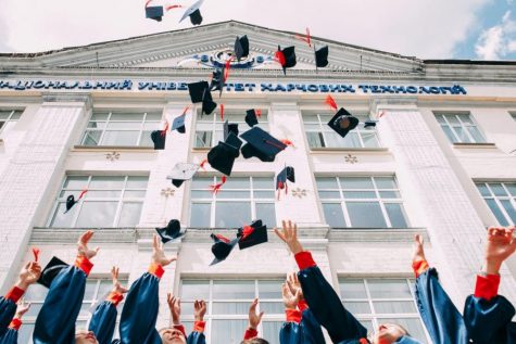 Graduates tossing caps in air