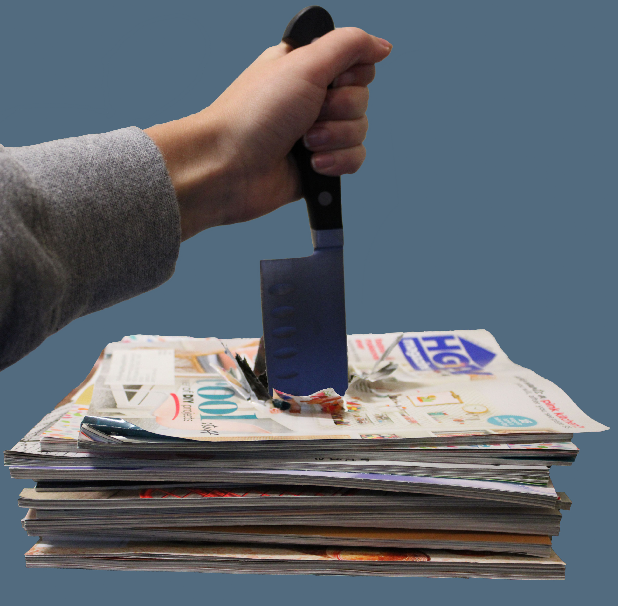 Knife through stack of newspapers