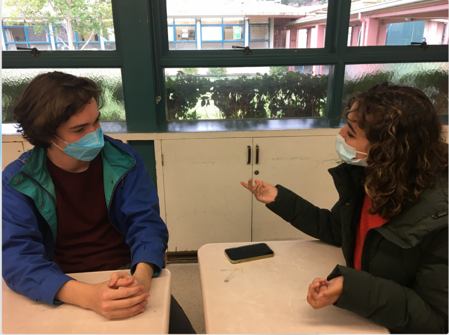 Two masked students in discussion