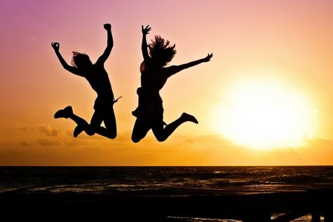 Two girls jumping on beach
