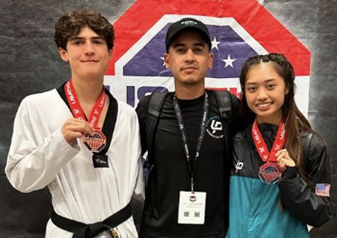 James Howe, center, owner of Living Proof Martial Arts & Fitness in Antoich, strikes a pose with Makeio Desadier, left, and Kaelynn Jae Agustin during the USA Taekwondo (USATKD) National Championship. Photo courtesy Living Proof