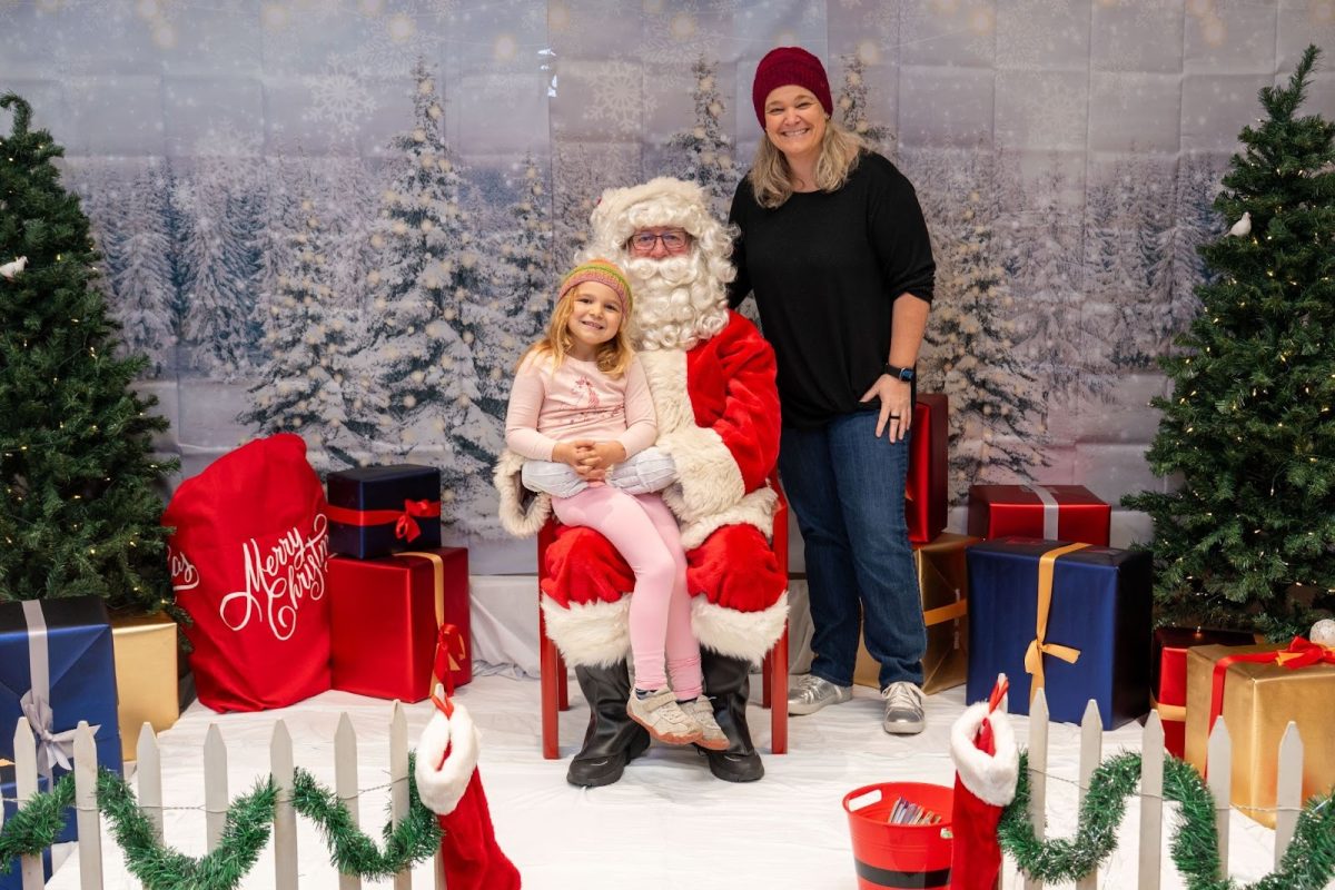 John Muir Health speech therapist Hillary Welty, and her daughter, Cam, take a picture with Santa, aka Mike Thomas, John Muir Health’s CEO. 
